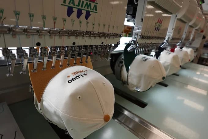 custom-hat-embroidery Embroidery machines creating San Marcos custom hats in a production facility.